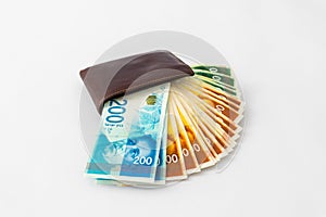 Ãârown leather wallet and stack of banknotes new Israeli shekels on white background