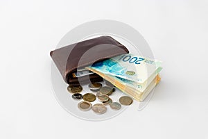 Ãârown leather wallet and stack of banknotes and several coins of new Israeli shekels on white background