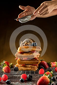 à¹‡How to powdering traditional homemade waffles with icing sugar. Waffles with ice cream, caramel sauce and fresh berries.