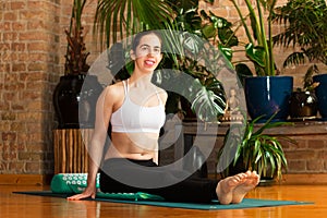 â€ŽYoung woman practicing yoga in studio