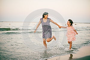 È˜i Mother and daughter enjoy together at sunet on the beach