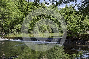 Ðœagnetic landscape of summer nature, green deciduous forest and river Iskar with small  waterfall close up in the Lozen mountain