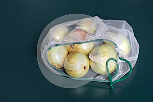 Ðžnion in eco-friendly packaging. Reusable bags for vegetables and fruits. Shopping in the store, retail. Eco-friendly packaging