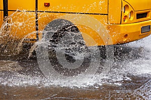 Ð’riving car on flooded road during flood caused by torrential rains. Cars float on water, flooding streets. Splash on car.