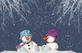 2 snowman sitting in the snow