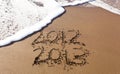 2012 and 2013 written in sand with waves Royalty Free Stock Photo