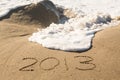 2013 in sand being covered by sea waves Royalty Free Stock Photo