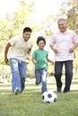 3 Generation Family Playing Football In Park Royalty Free Stock Photo