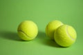 3 tennis balls ond green background