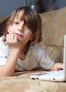 6 year old boy lying on the sofa with his laptop Royalty Free Stock Photo