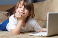 6 year old boy lying on the sofa with his laptop Royalty Free Stock Photo