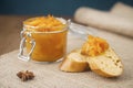 AA jar of confiture from orange fruits and pieces of French baguette with star anise on the burlap