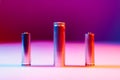 AA and 8650 Li-ion silver batteries on illuminated by multicolored light Royalty Free Stock Photo