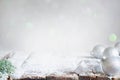 Aabstract christmas background with silver baubles and fir on empty snowy table Royalty Free Stock Photo