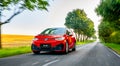 The Volkswagen VW ID.3 Electric compact car driving on a road at sunset with modern urban background - motion blur chasing shot Royalty Free Stock Photo