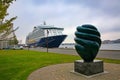 Aalborg Waterfront - Kvindens Plads with sculpture in the harbour and a cruise ship docked in the port behind, Aalborg, Denmark.