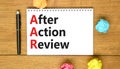 AAR After action review symbol. Concept words AAR After action review on beautiful white note. Beautiful wooden table wooden