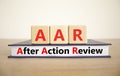 AAR After action review symbol. Concept words AAR After action review on beautiful wooden blocks and book. Beautiful white