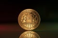 Aave crypto coin placed on reflective surface in dark background