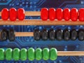 Abacus in front of circuit board dark