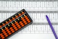 Abacus for mental arithmetic on background of sheet of paper with examples for calculation Royalty Free Stock Photo