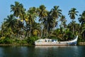 Abadoned ocean fishing boat along the canal Kerala backwaters shore with palm trees between Alappuzha and Kollam, India Royalty Free Stock Photo