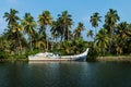 Abadoned ocean fishing boat along the canal Kerala backwaters shore with palm trees between Alappuzha and Kollam, India Royalty Free Stock Photo