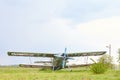 Abandoned aircraft plane standing in the field against cloudy blue sky. Small propeller plane at the airplane cemetery. Royalty Free Stock Photo