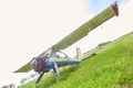 Abandoned aircraft plane standing in the field against cloudy blue sky. Small propeller plane at the airplane cemetery. Royalty Free Stock Photo