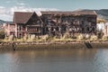 Abandoned ancient building on riverbank. Weathered facade of old public house in the river. Scary abandoned house, toned. Royalty Free Stock Photo