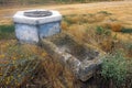 Abandoned ancient trough for cattle near a closed well of stone