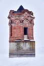 Abandoned ancient water tower in the middle of a frozen river during a snowfall Royalty Free Stock Photo
