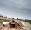 Abandoned red barn with modern barn in background Royalty Free Stock Photo