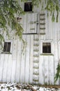 Abandoned barn exterior wall with ladders and windows Royalty Free Stock Photo