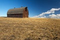 Abandoned barn in harvested wheat field Royalty Free Stock Photo