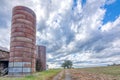 Abandoned barn with silo under stormy clouds Royalty Free Stock Photo