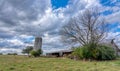 Abandoned barn with silo under stormy clouds Royalty Free Stock Photo