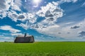 An abandoned barn surrounded by wheat field on the Canadian prairies in Saskatchewan Royalty Free Stock Photo