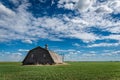 An abandoned barn surrounded by a wheat field on the prairies in Saskatchewan Royalty Free Stock Photo