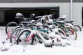 Abandoned bicycles covered with snow near apartment building parking lot in winter season