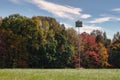 Abandoned birdhouse with colorful Autumn trees as background