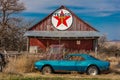 Abandoned blue Camaro Chevrolete in front of deserted Texaco Station, remote part of Nebraska