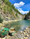 Abandoned boat in flooded quarry with blue crystal water.