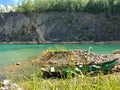 Abandoned boat in flooded quarry with blue crystal water.