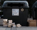 Abandoned books in front of a garbage container