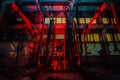 Abandoned brick factory at night. Old rusty brick forming machine and conveyor illuminated by color light. Abstract industrial