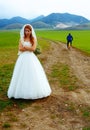 Abandoned bride and groom running away on a bike - funny wedding concept. Royalty Free Stock Photo