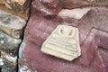 Abandoned broken Buddha image amulet left outside ruined sandstone pagoda in temple, northeastern Thailand