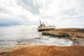 Abandoned broken ship-wreck beached on rocky sea shore. Royalty Free Stock Photo