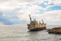 Abandoned broken ship-wreck beached on rocky sea shore. Royalty Free Stock Photo